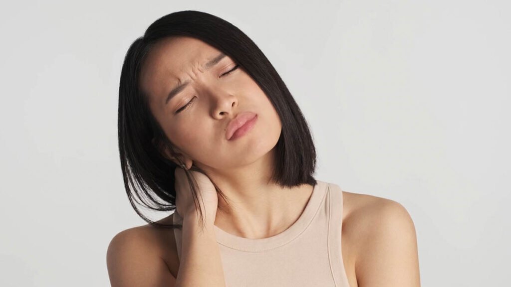 Upset tired Asian woman feeling pain in neck and head after hard