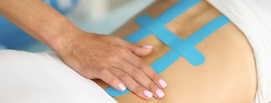 Kinesiology Tape Benefits for Athletes in Sports | Thailand Medical Blog Kinesio taping of back is effective method of treating scoliosis and pain in clinic with elastic bands.